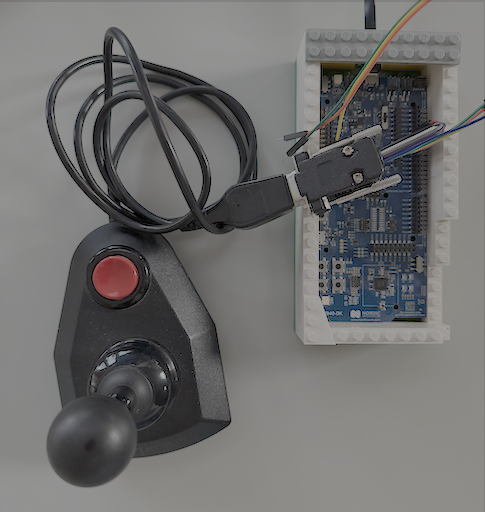An old joystick connected to a nRF52840 DK board via a custom made breakout cable.